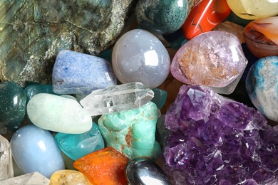 Different beautiful gemstones as background, top view
