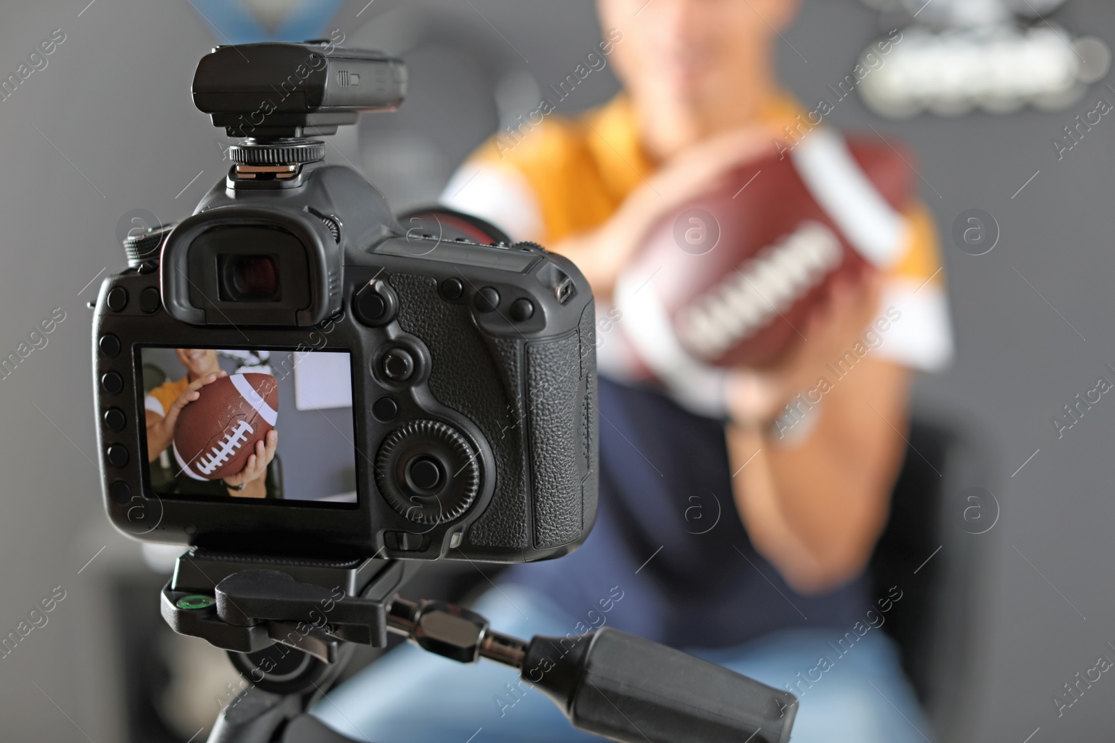 Photo of Sport blogger recording video indoors, selective focus on camera display. Space for text