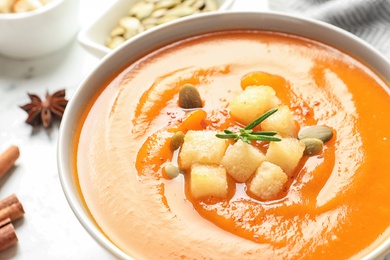 Bowl of tasty sweet potato soup on table, closeup. Space for text