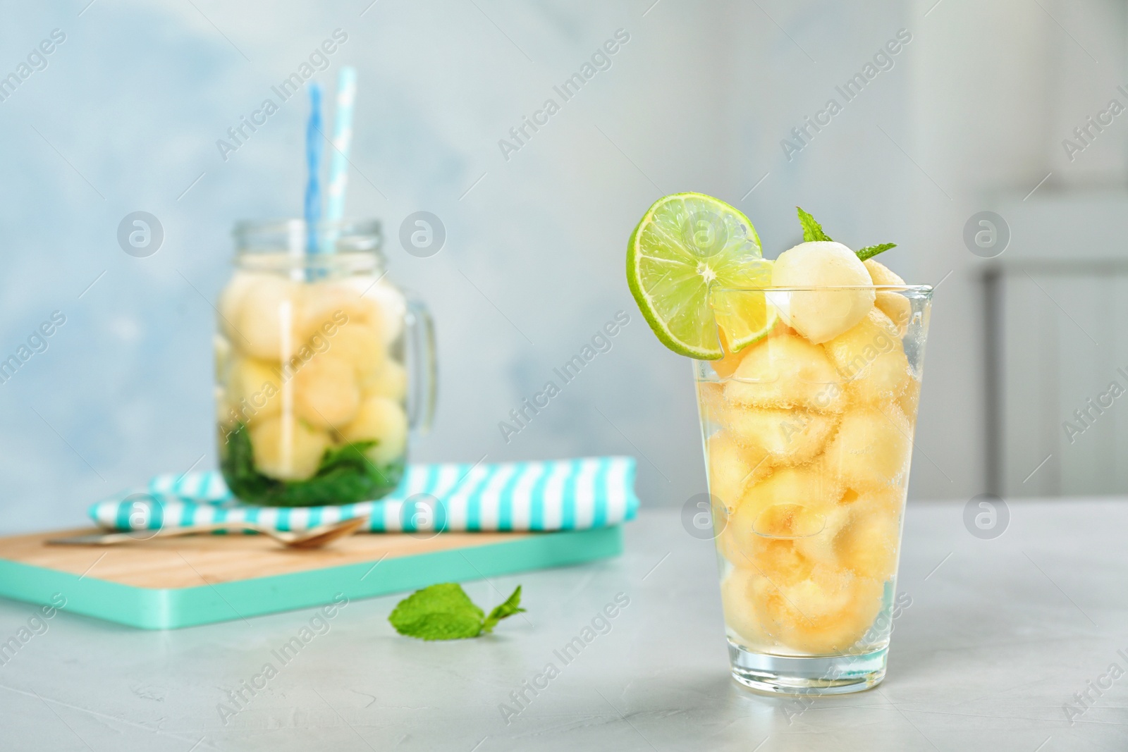 Photo of Glass with tasty melon ball drink on table