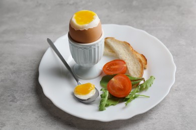 Photo of Breakfast with soft boiled egg on grey table