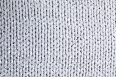 Photo of Warm knitted sweater as background, closeup view