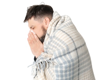 Man wrapped in blanket suffering from cold on white background