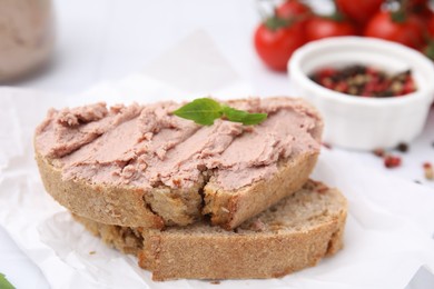 Photo of Delicious liverwurst sandwich with basil on white table, closeup
