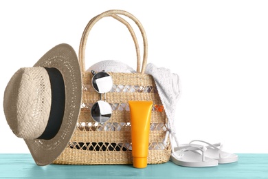 Photo of Set of beach accessories on blue wooden table, white background