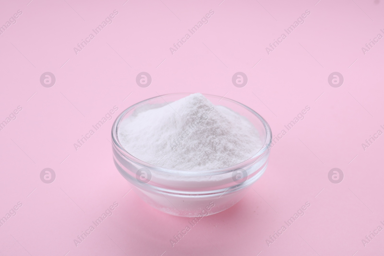 Photo of Bowl of sweet powdered fructose on pink background