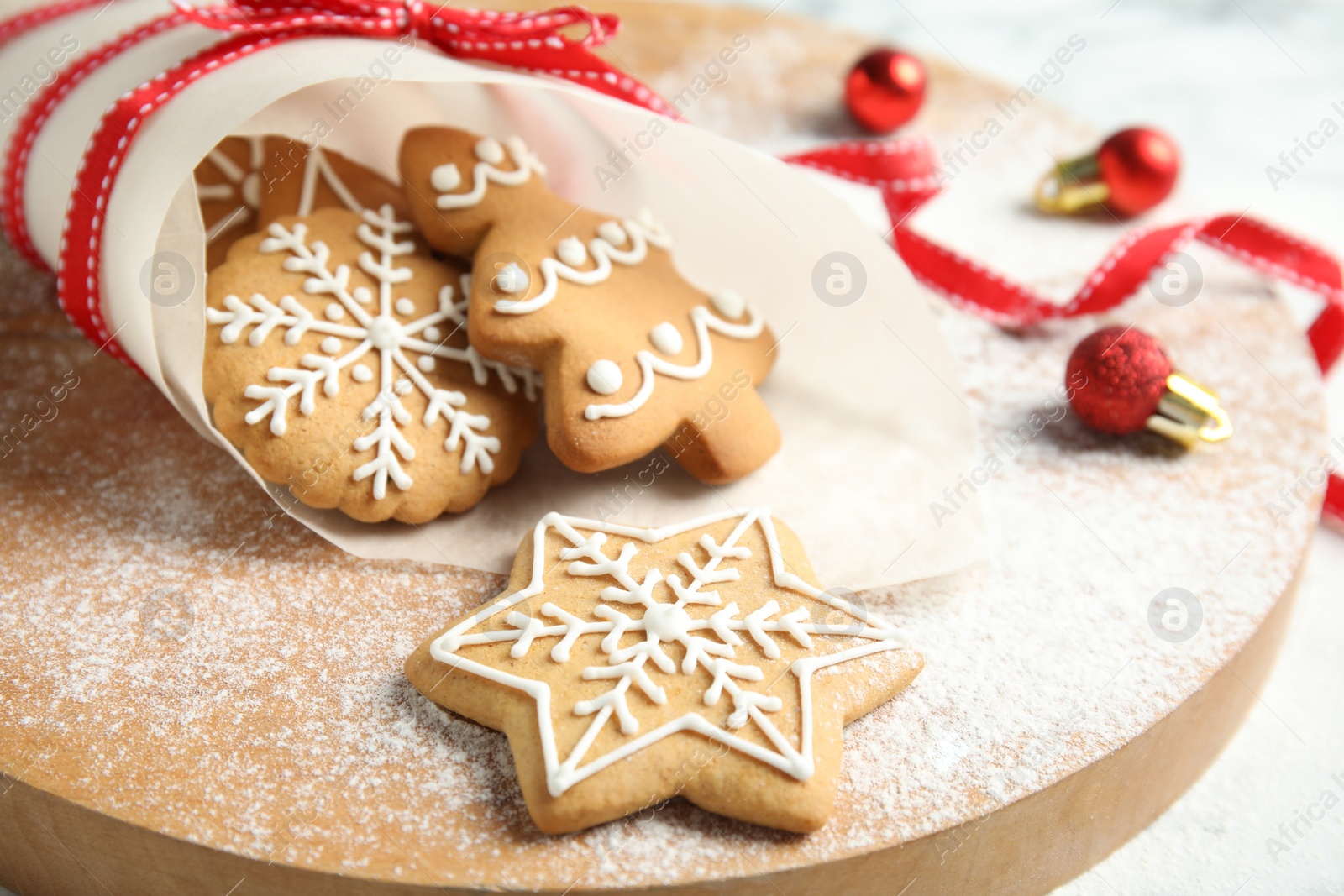 Photo of Tasty decorated Christmas cookies on wooden board, closeup