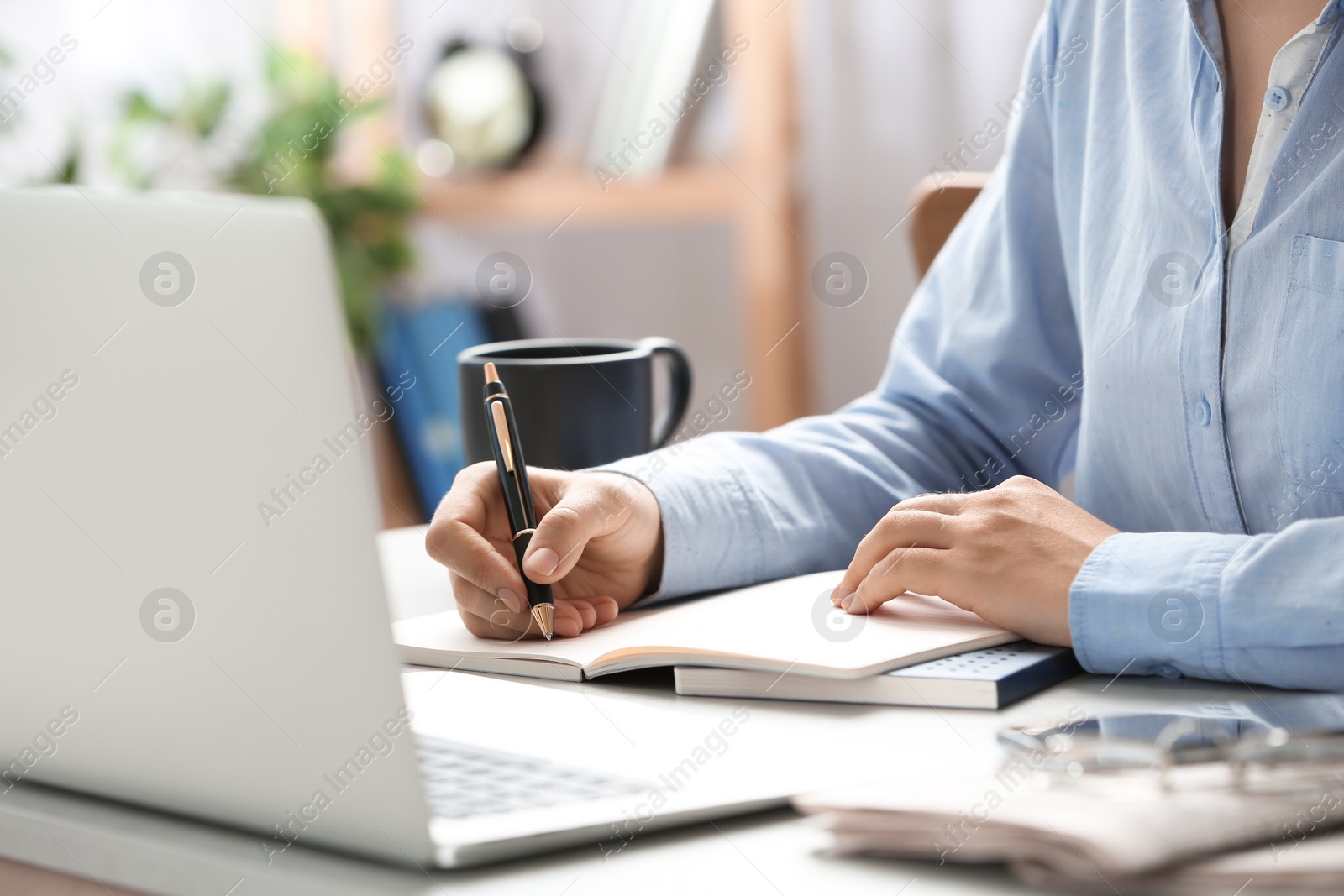 Photo of Journalist working at table in office, closeup