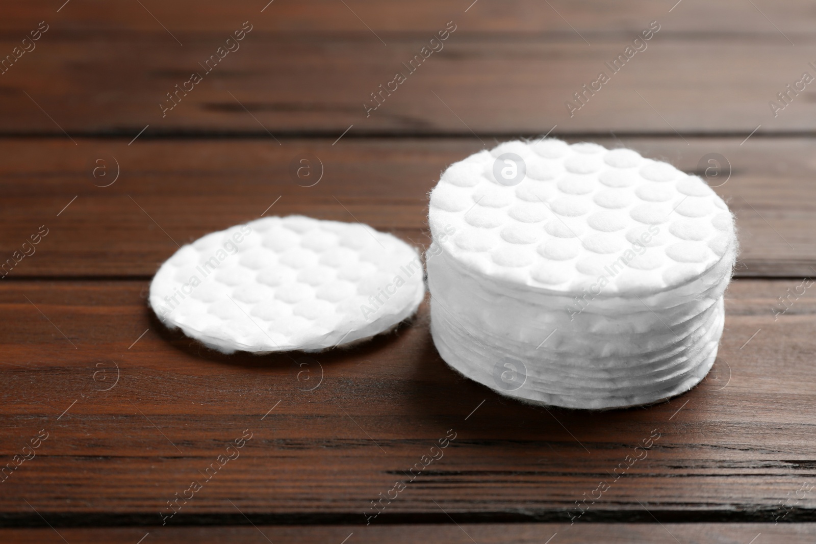 Photo of Stack of cotton pads on wooden background