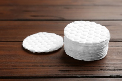 Stack of cotton pads on wooden background