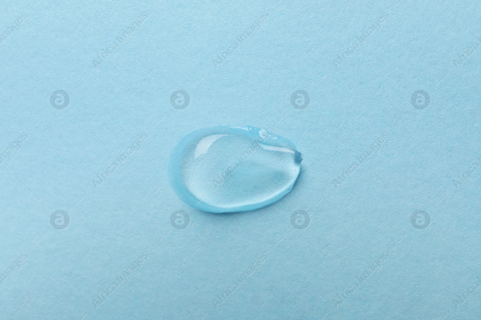 Photo of Swatch of cosmetic gel on light blue background, top view