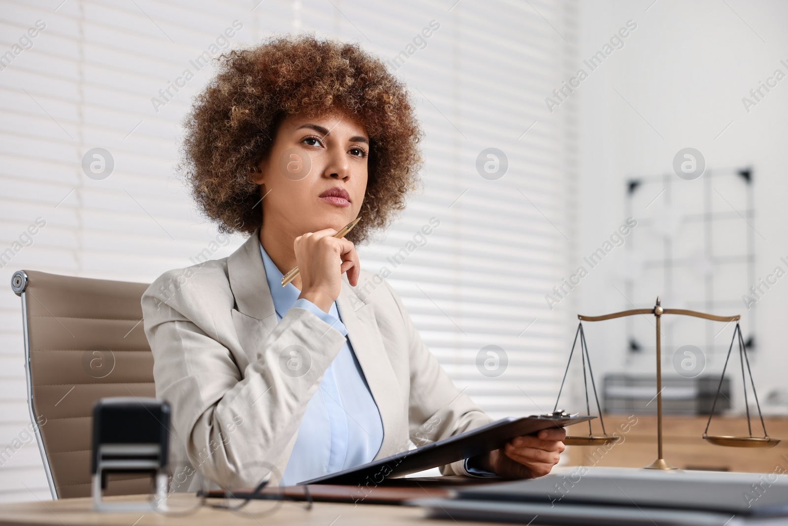 Photo of Notary with clipboard and pen at workplace in office