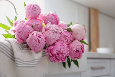 Photo of Bouquet of beautiful pink peonies on counter in kitchen