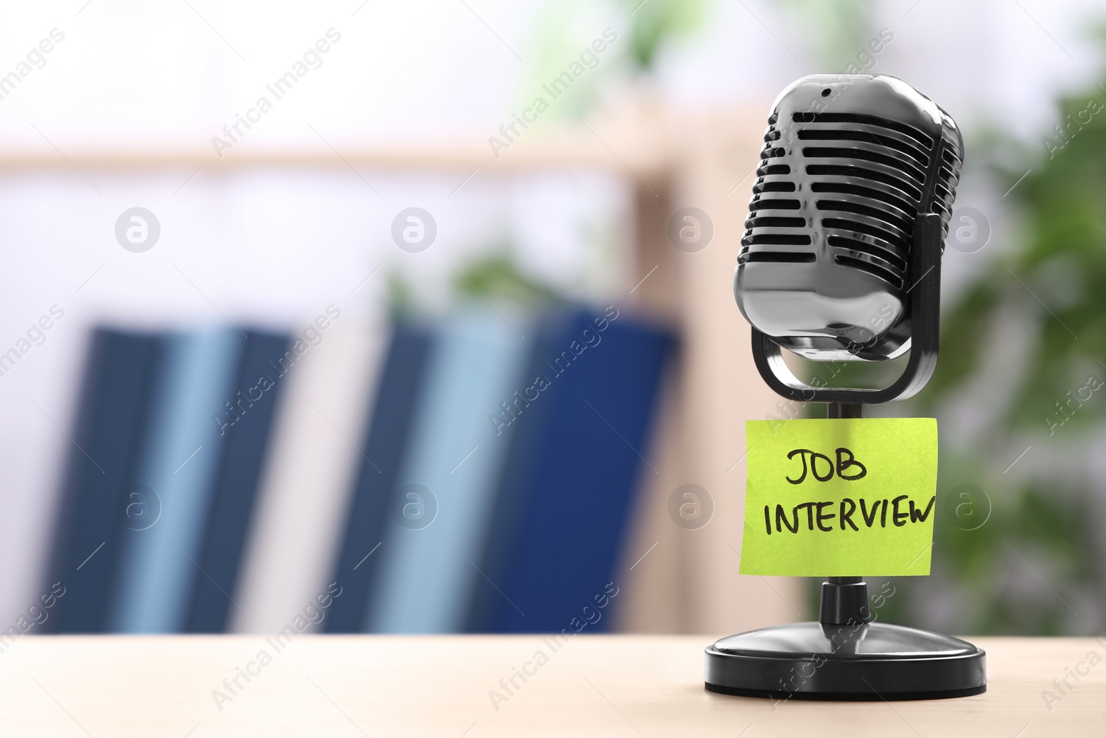Photo of Retro microphone and reminder note with words JOB INTERVIEW on table indoors, space for text