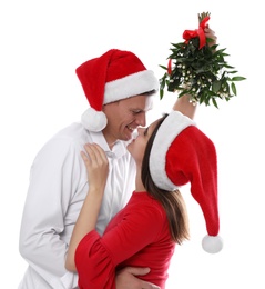 Photo of Happy couple standing under mistletoe bunch on white background