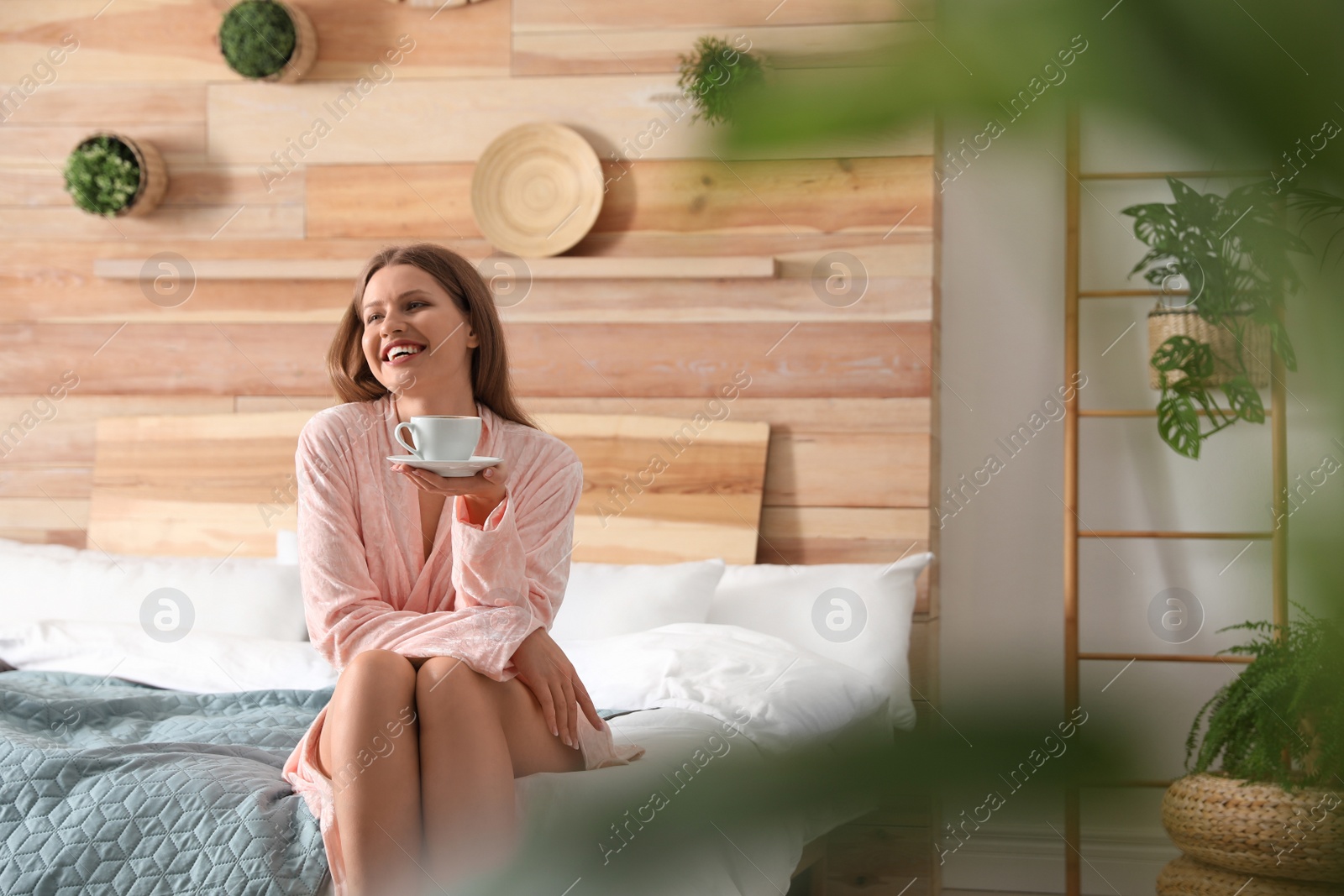 Photo of Woman drinking coffee in bedroom with green plants. Home design ideas