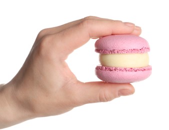 Photo of Woman holding delicious pink macaron on white background, closeup