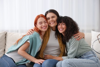 Photo of Portrait of happy young friends hugging at home