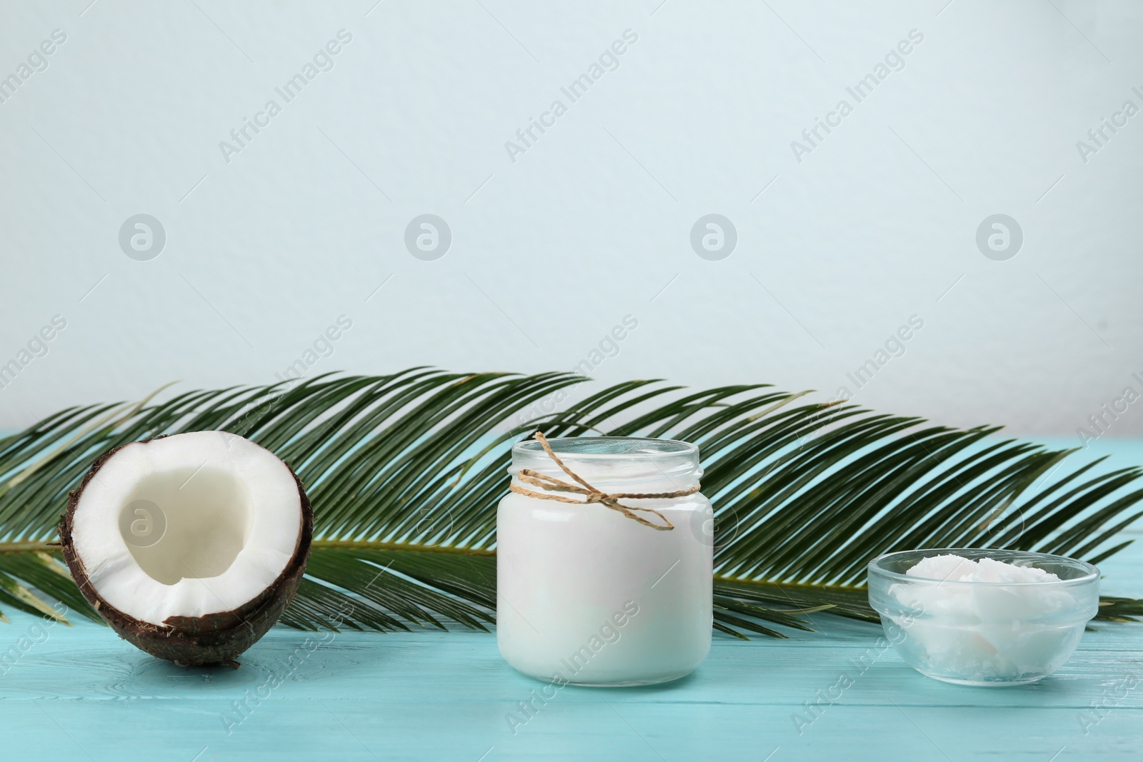 Photo of Composition with organic coconut oil on light blue wooden table, space for text. Healthy cooking