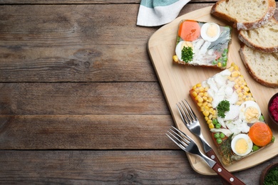 Photo of Delicious fish aspic served on wooden table, flat lay. Space for text