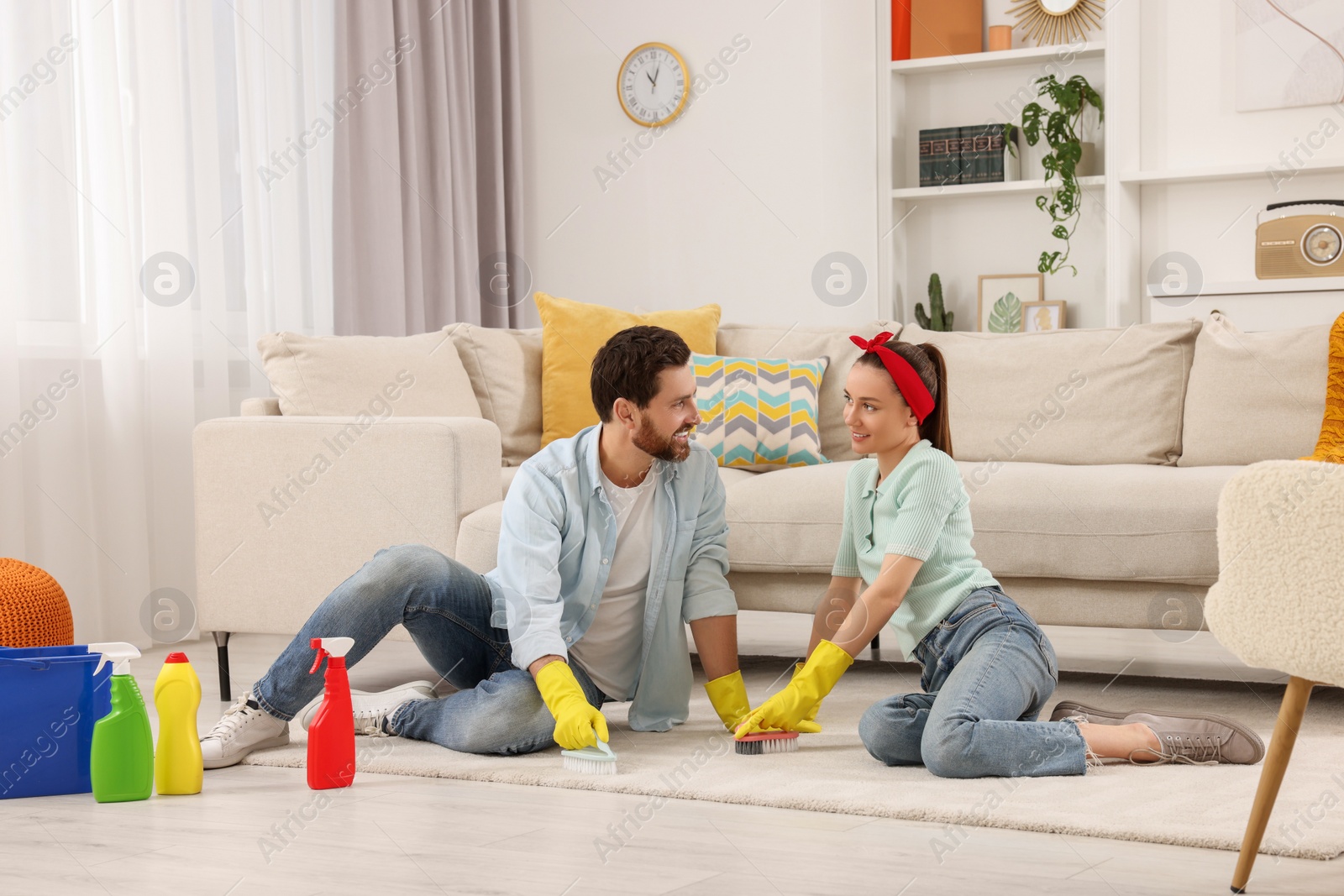 Photo of Spring cleaning. Couple tidying up living room together