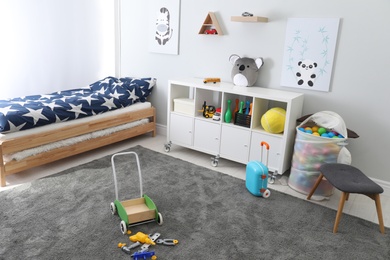 Photo of Cute child's room interior with toys and modern furniture