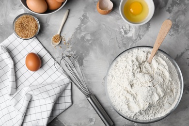 Photo of Composition with flour, eggs and brown sugar on grey background