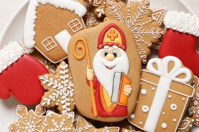 Photo of Tasty gingerbread cookies on plate, top view. St. Nicholas Day celebration