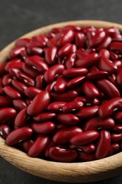 Photo of Raw red kidney beans in wooden bowl, closeup