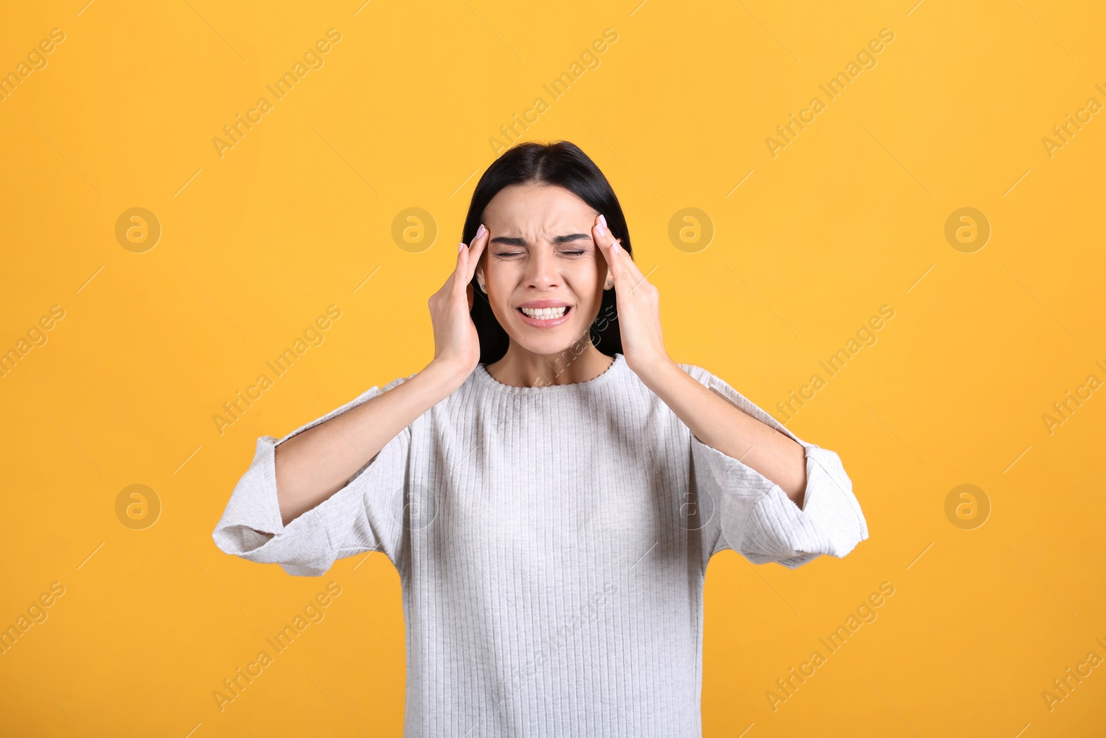 Photo of Portrait of stressed young woman on yellow background