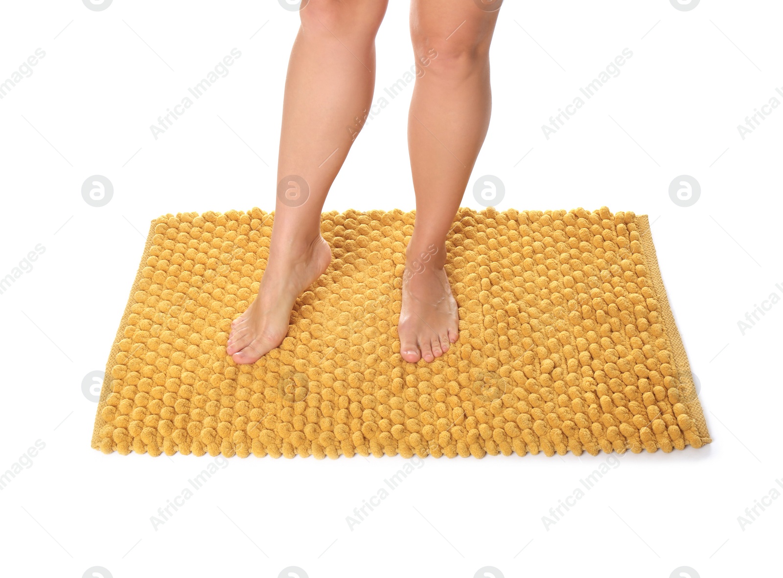 Photo of Woman standing on soft orange bath mat against white background, closeup