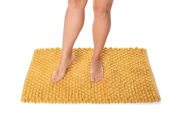 Photo of Woman standing on soft orange bath mat against white background, closeup