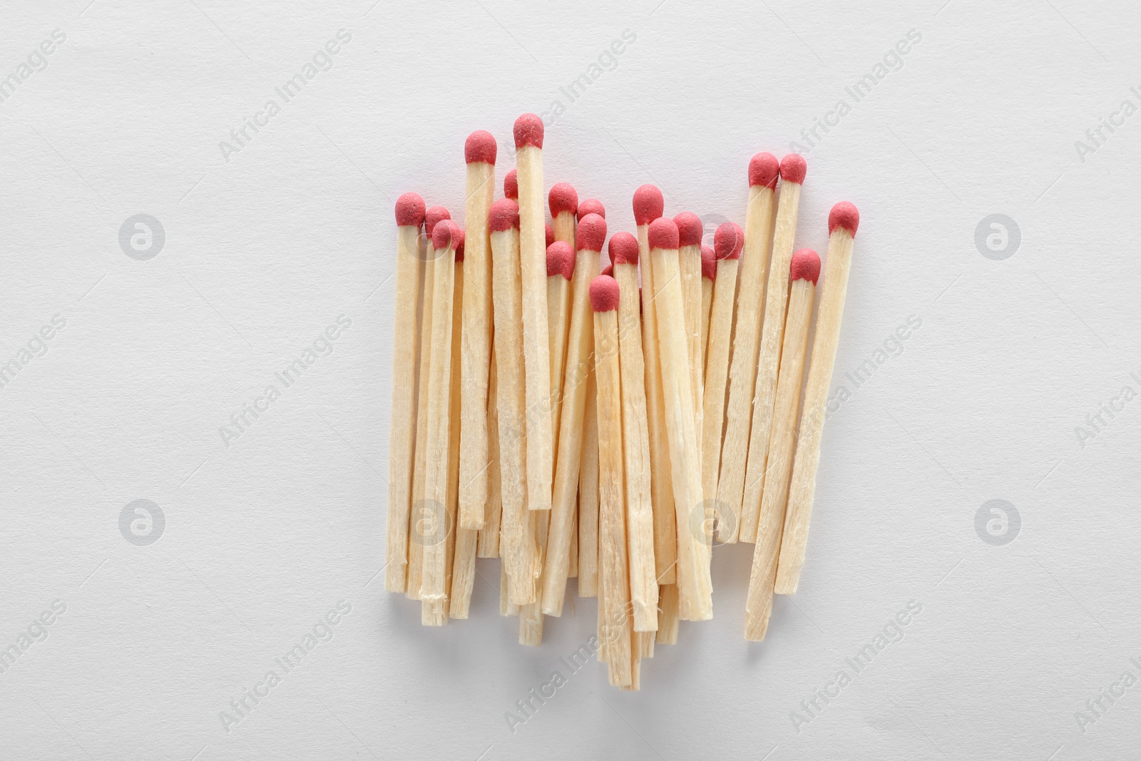 Photo of Pile of wooden matches on white background, top view