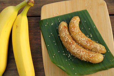 Delicious fresh and fried bananas on wooden table, closeup