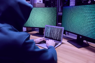 Photo of Hacker working with computers at wooden table. Cyber attack