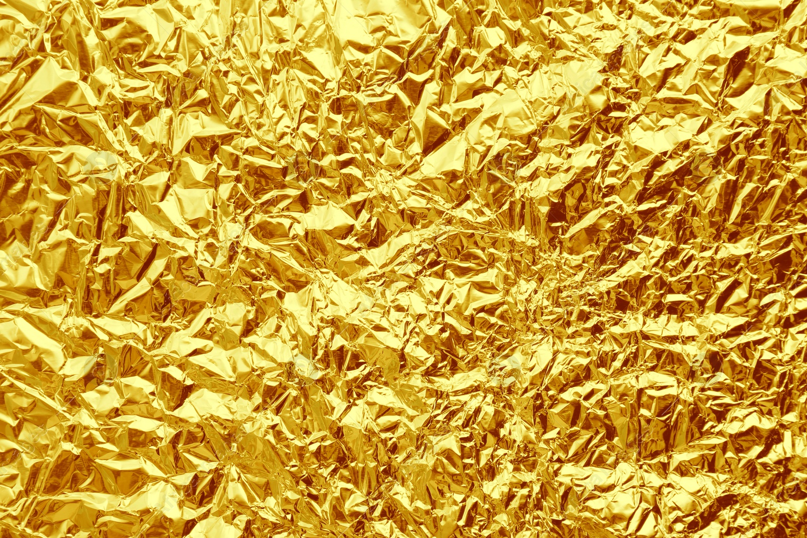 Image of Crumpled golden foil as background, closeup view