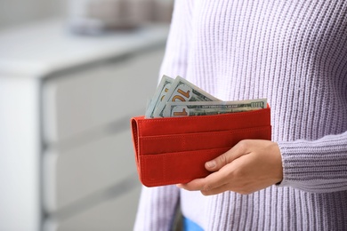 Photo of Woman with American money in wallet indoors, closeup