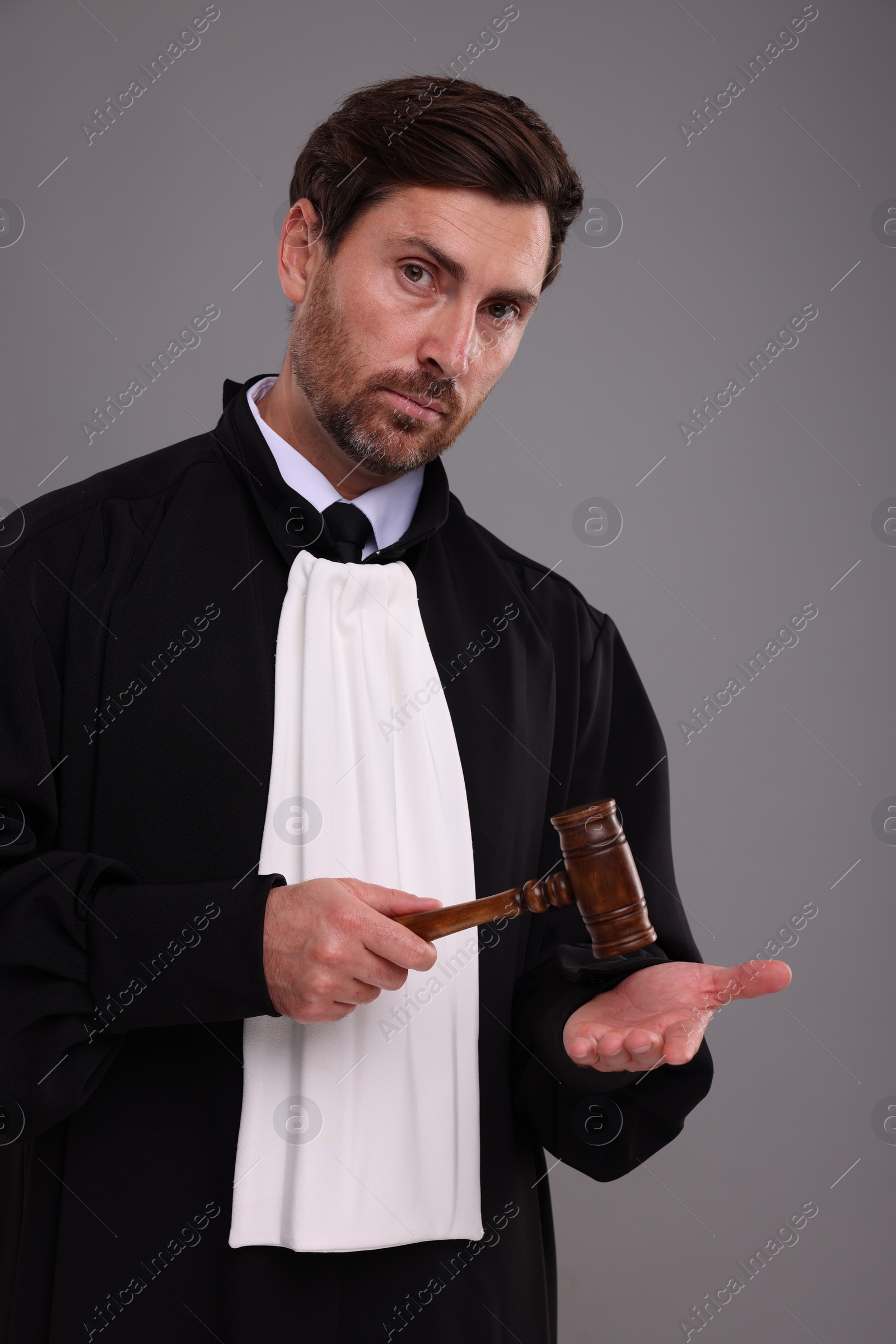 Photo of Portrait of judge with gavel on grey background