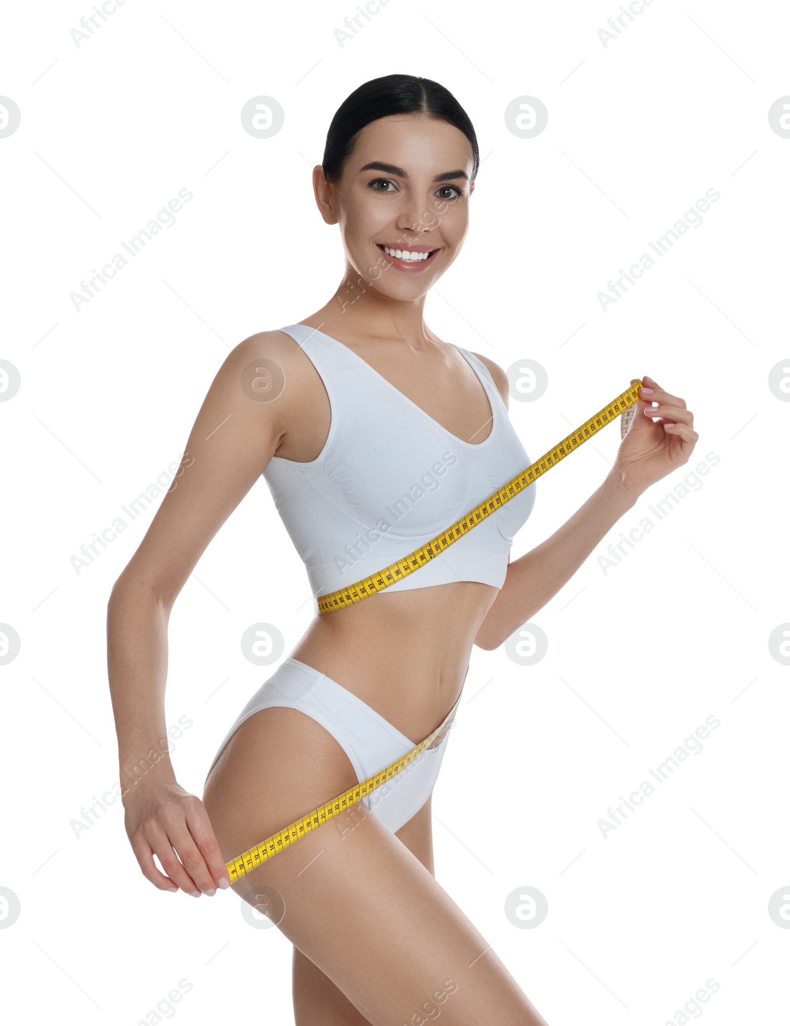 Photo of Young woman measuring waist with tape on white background