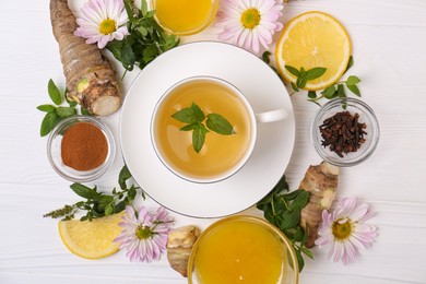 Photo of Flat lay composition with cup of delicious tea, honey and ginger on white wooden table