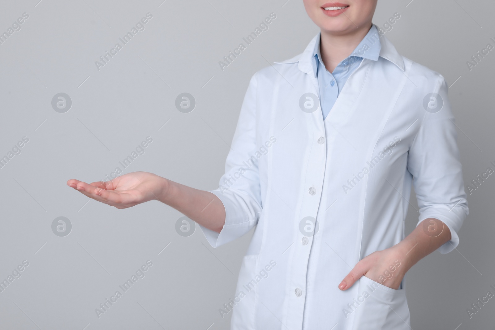 Photo of Dental assistant holding something on light grey background, closeup