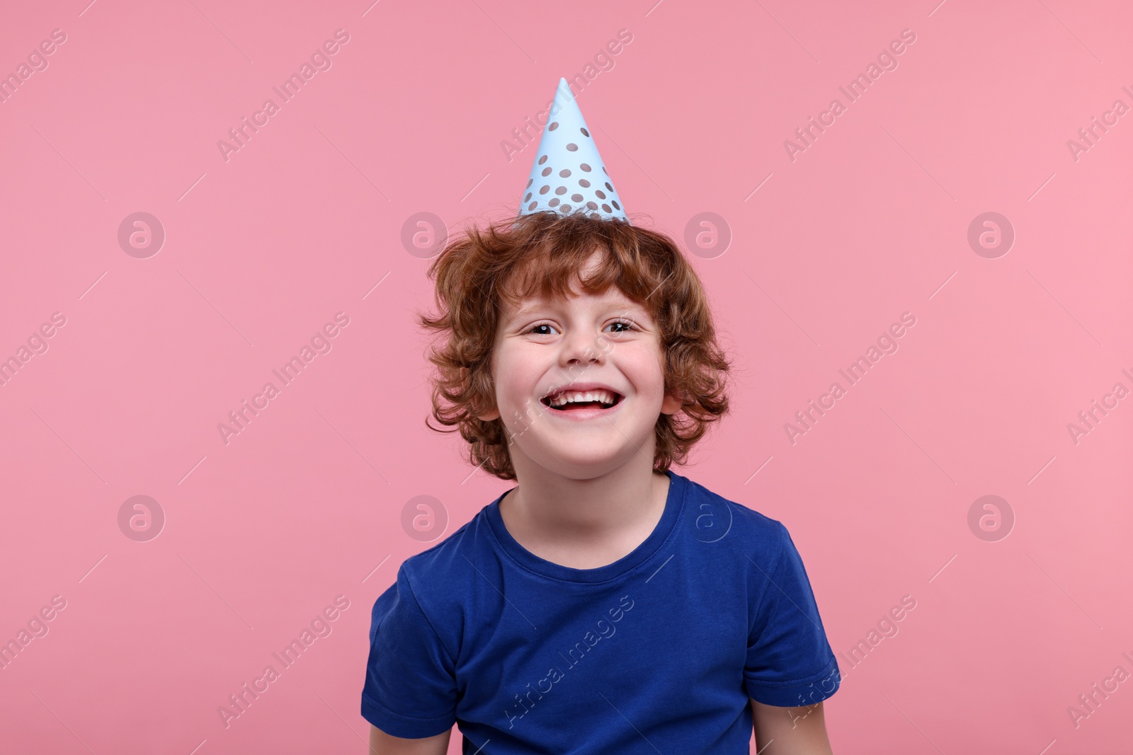 Photo of Happy little boy in party hat on pink background