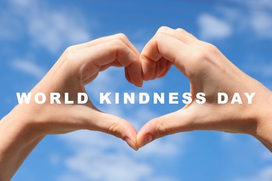 World Kindness Day. Woman showing heart gesture with hands against blue sky, closeup