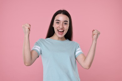 Photo of Portrait of happy surprised woman on pink background