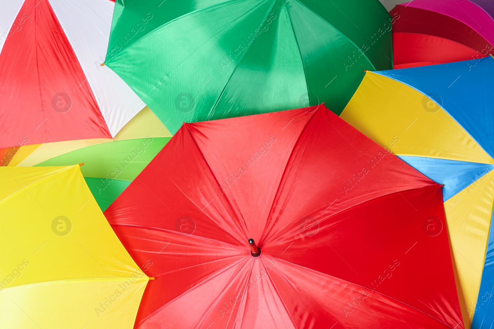 Image of Many bright umbrellas as background, top view