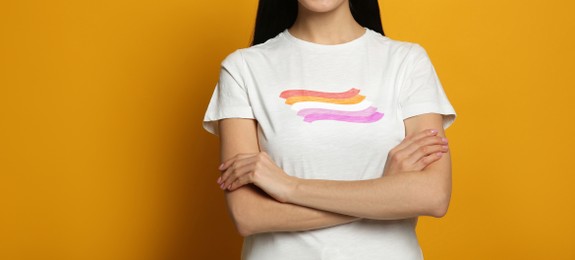 Image of Young woman wearing white t-shirt with lesbian flag on orange background, banner design. LGBT concept