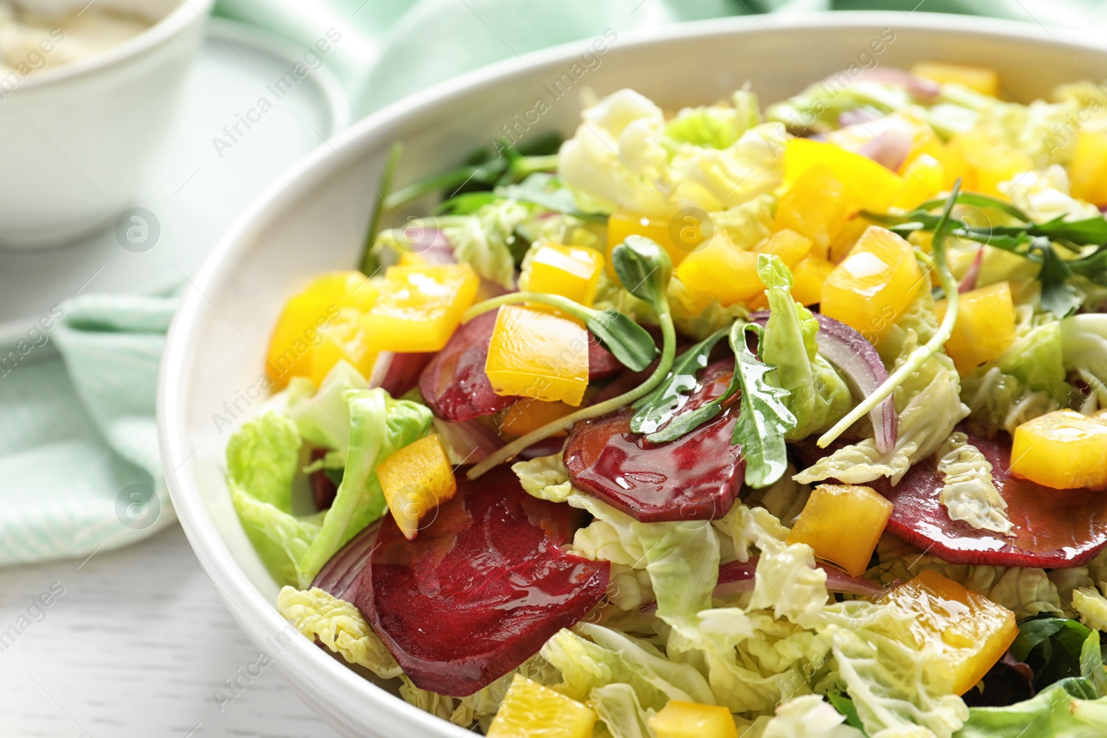 Photo of Bowl with tasty beets salad on table, closeup