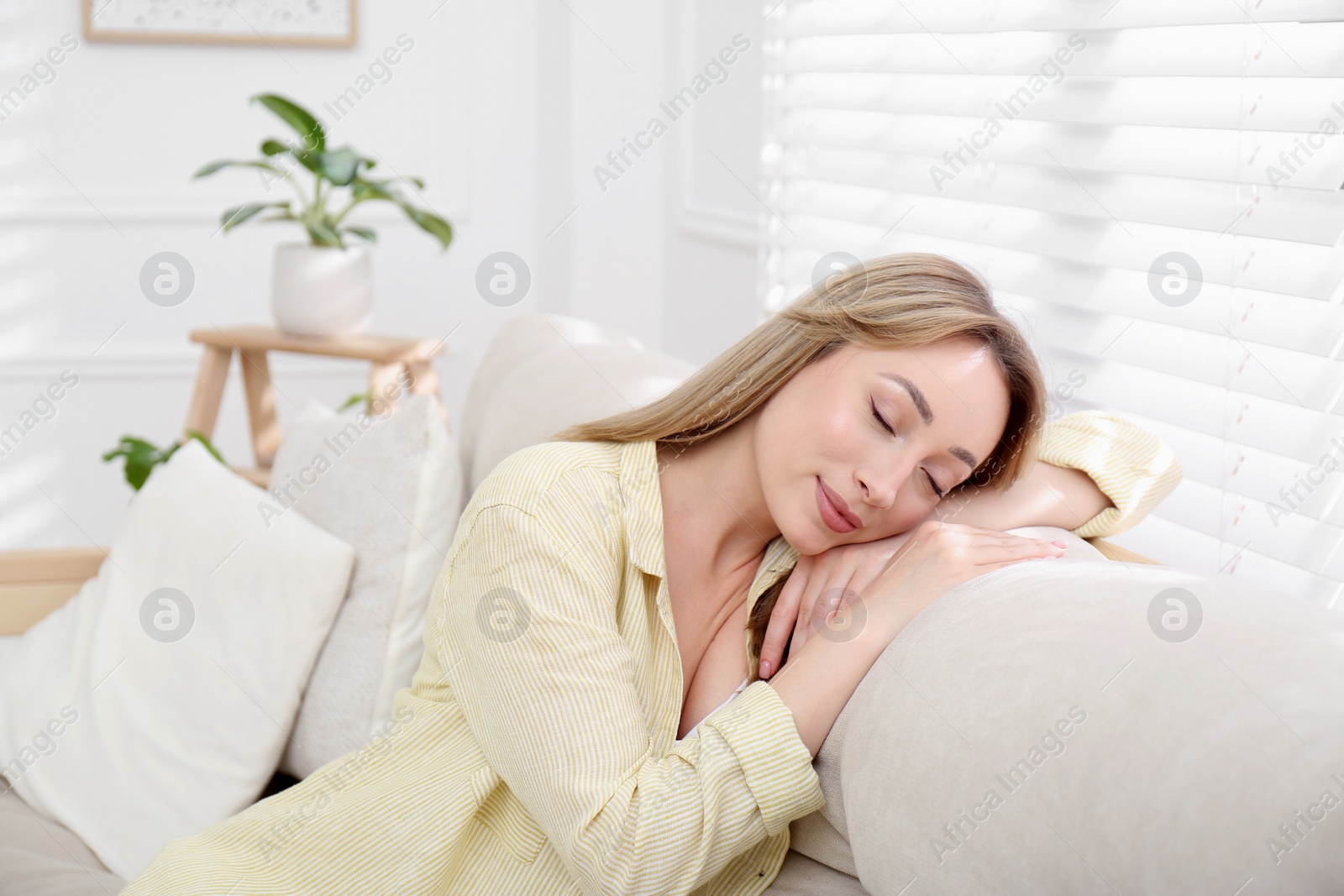 Photo of Beautiful young woman relaxing on sofa at home