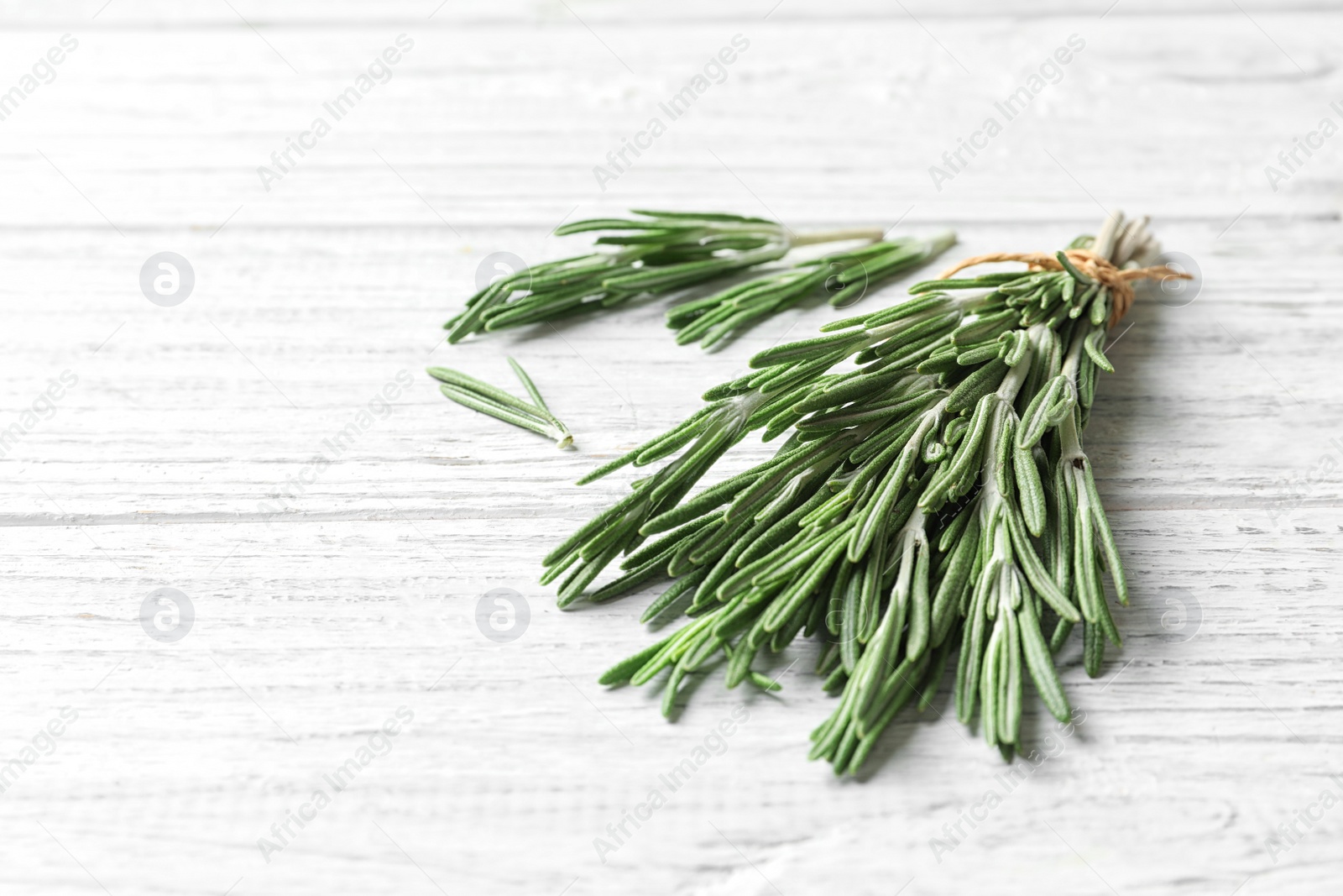 Photo of Fresh rosemary twigs on wooden table