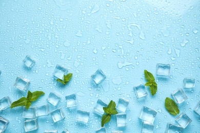 Photo of Ice cubes, mint and space for text on turquoise background, flat lay. Refreshing drink ingredients